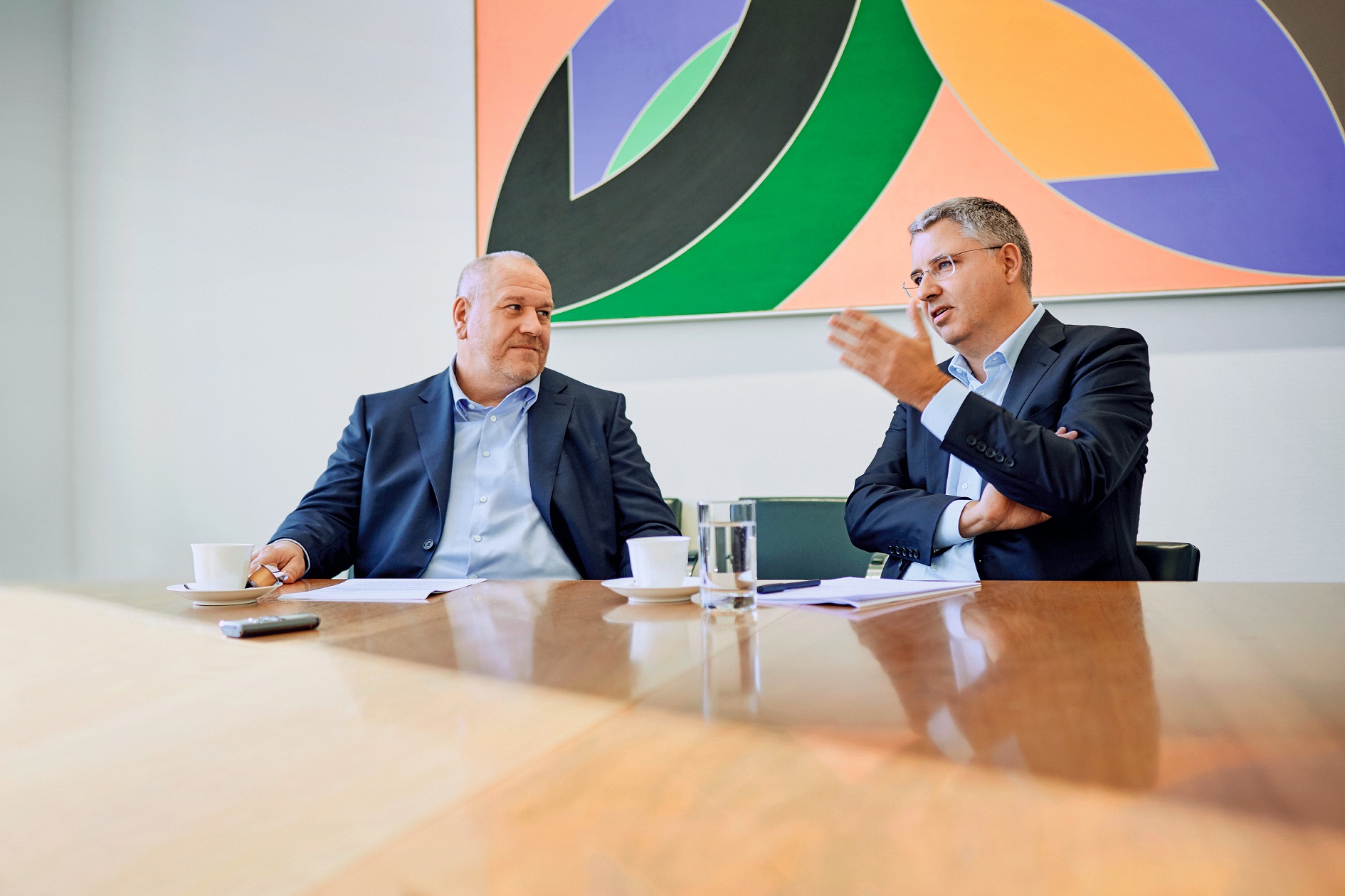 Severin Schwan and Matthias Altendorf sitting next to each other on a table