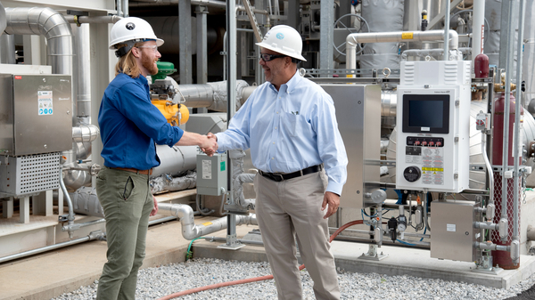 Shaking hands with customer in front of Raman Rxn5 analyzer at Long Ridge Energy